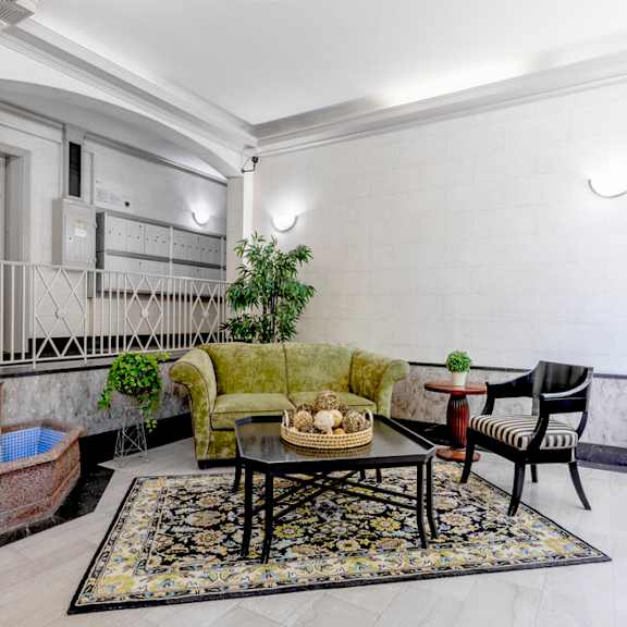a living room with a green couch, a coffee table, and a fireplace.
