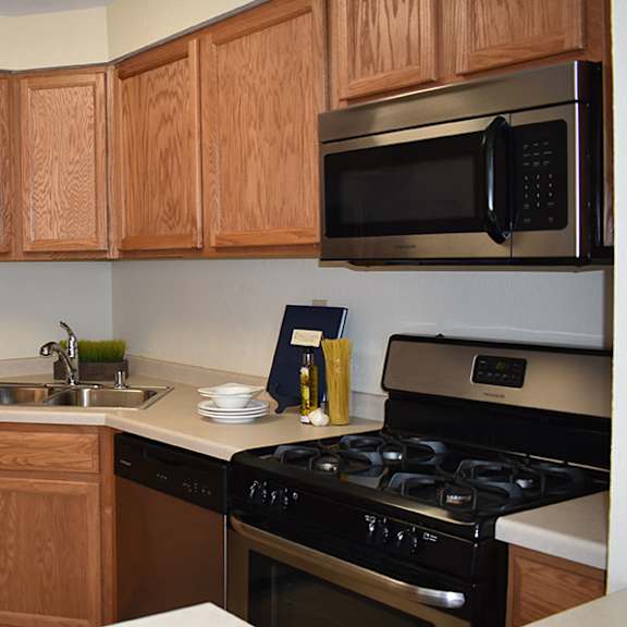 a kitchen with wooden cabinets and a stainless steel refrigerator.
