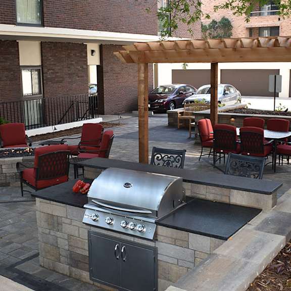 a patio with a grill and seating area.