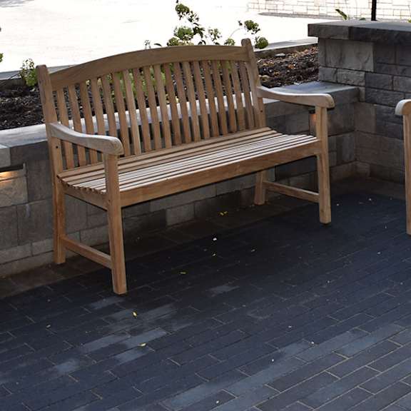two wooden benches are placed on a patio.