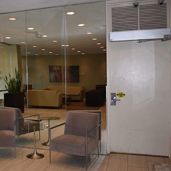 a glass wall separates the office from the hallway.