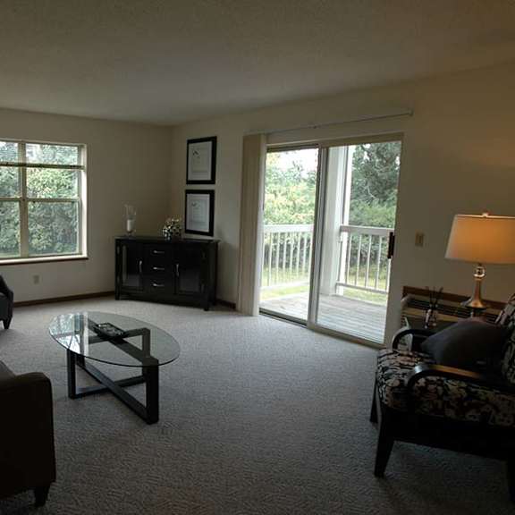 a living room with a couch, chair, and lamp.