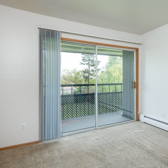 a room with a sliding glass door leading to a balcony.