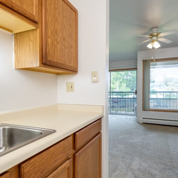 a kitchen with wooden cabinets and a stainless steel sink.