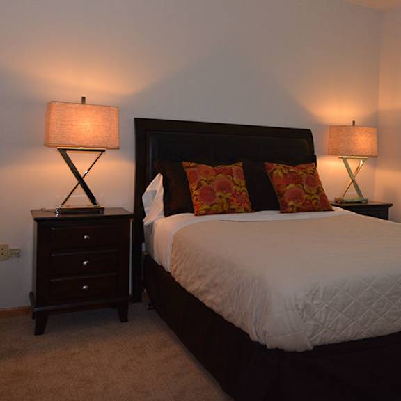 a bedroom with a large bed and two lamps.