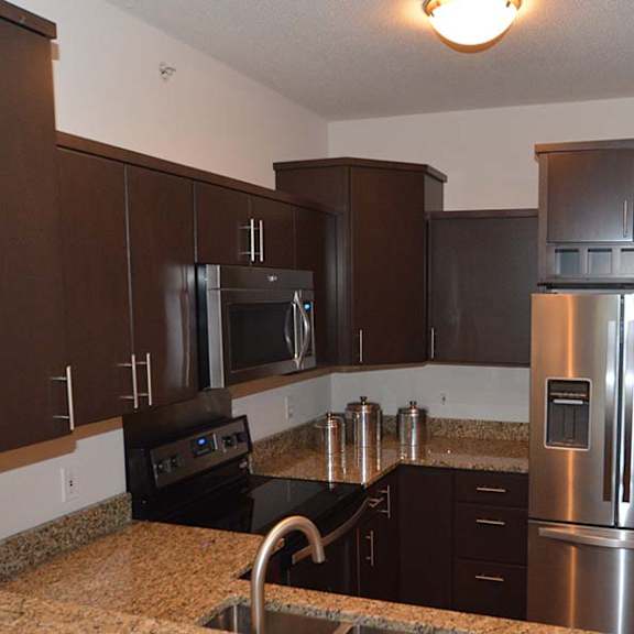 a kitchen with brown cabinets and a black stove top.