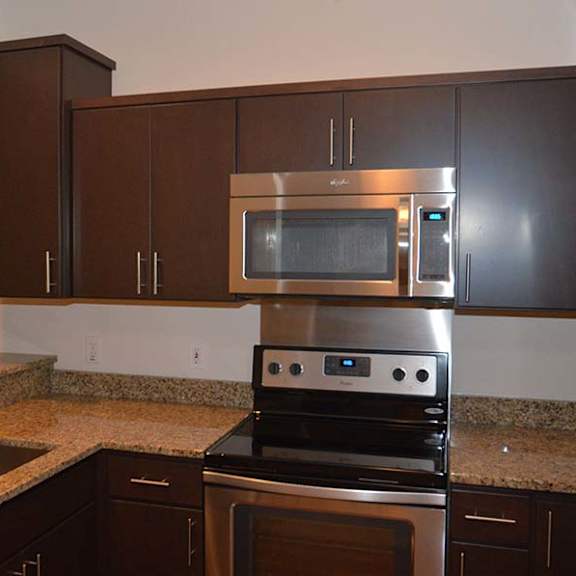 a kitchen with a stove, microwave, and refrigerator.
