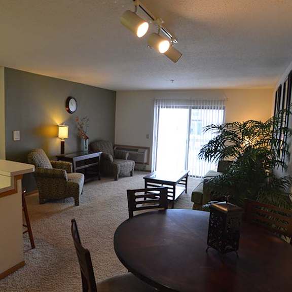 a living room with a kitchen area in the background.
