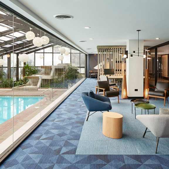 a modern indoor space with a pool and comfortable seating.