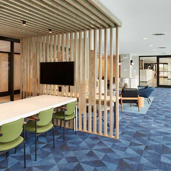 a conference room with a long table and green chairs.