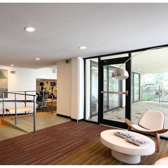 a modern living room with a white chair and a wooden floor.