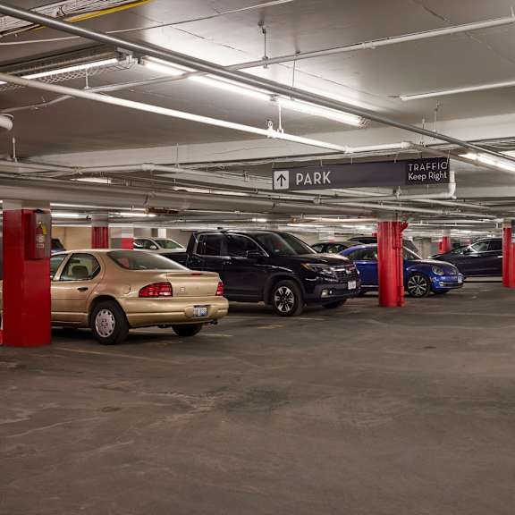 a parking garage with cars parked in red pillars.