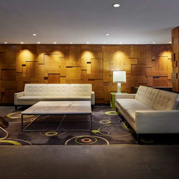 a modern living room with a white sofa and a wooden backdrop.