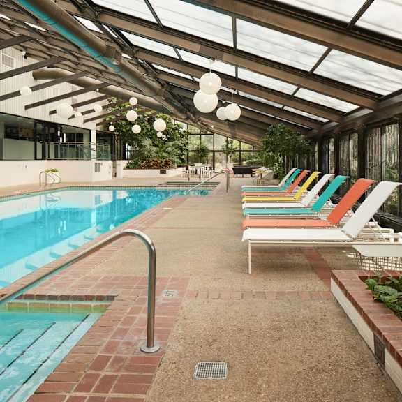 a pool with a metal railing and a glass ceiling.