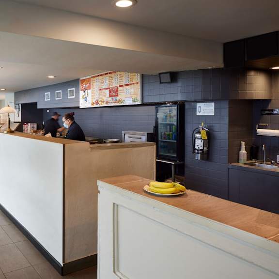 a white reception desk with a yellow plate on top.