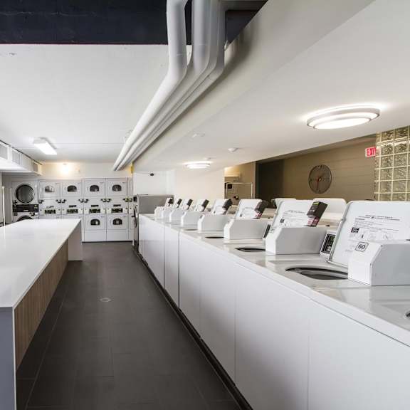 a long white counter with a white wall and a clock on the wall.