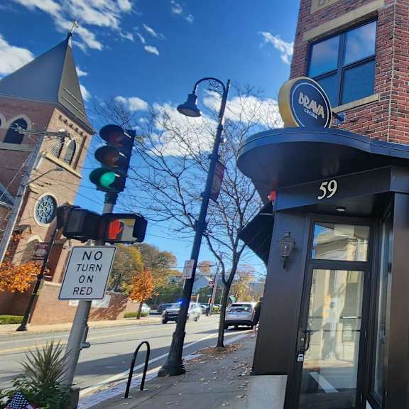 a brick building with a black awning and a sign that says "brava" on it.