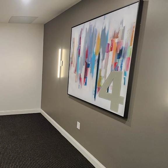 a hallway with a large painting on the wall and a number 4 on the painting.