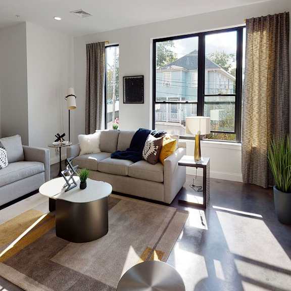 a modern living room with a grey sofa, a coffee table, and a television.