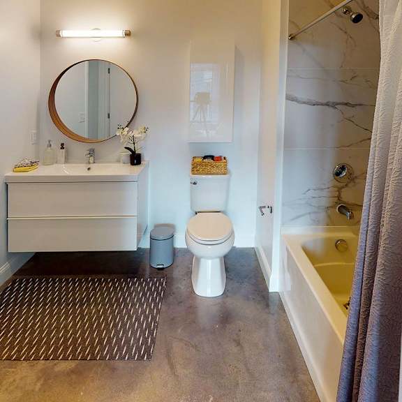 a bathroom with a toilet, sink, and mirror.