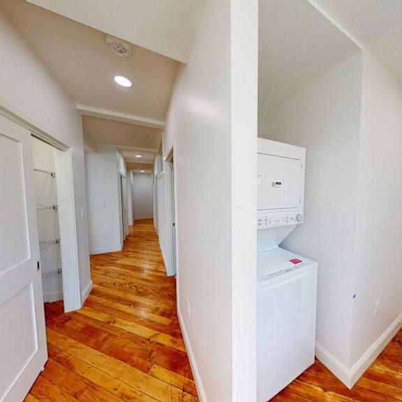 a hallway with a washing machine in the corner.