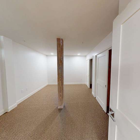 a long hallway with a carpeted floor and white walls.
