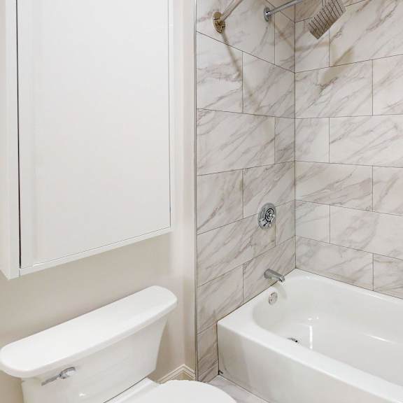 a white bathroom with a tub and toilet.