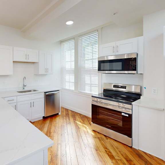 a kitchen with white cabinets and a white counter top.