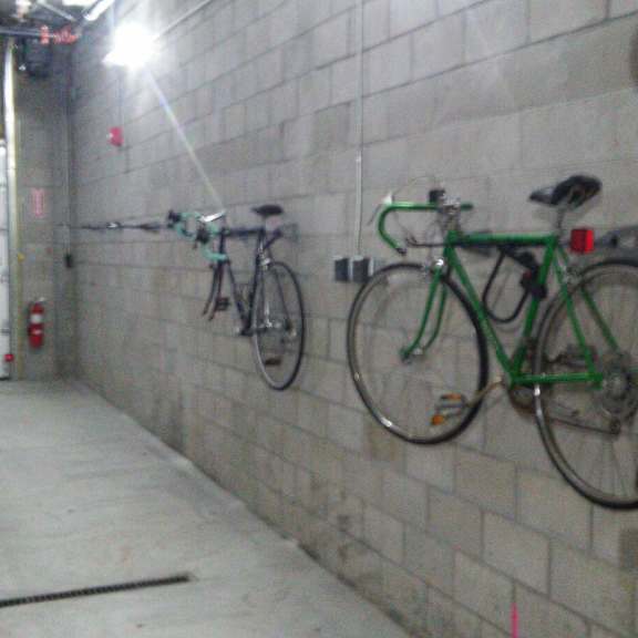 two bikes are parked on a wall in a garage.