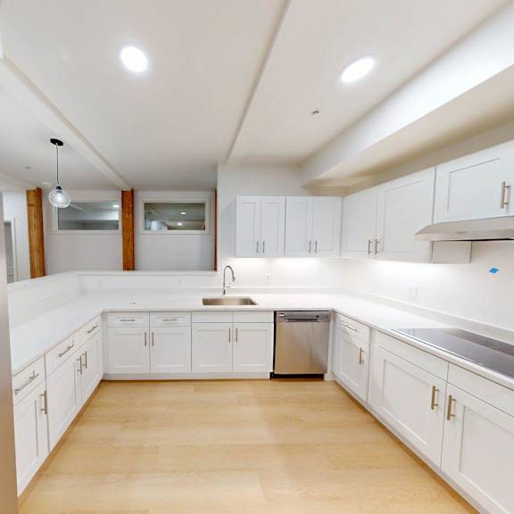a modern kitchen with white cabinets and a stainless steel refrigerator.