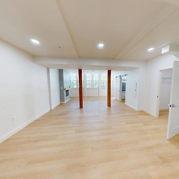 a large empty room with wooden floors and white walls.
