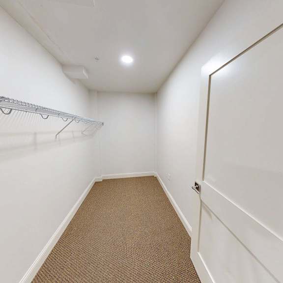 a white hallway with a metal rack on the wall.