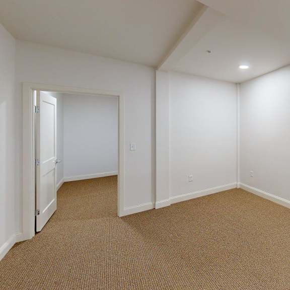 a room with white walls and carpeted floor.