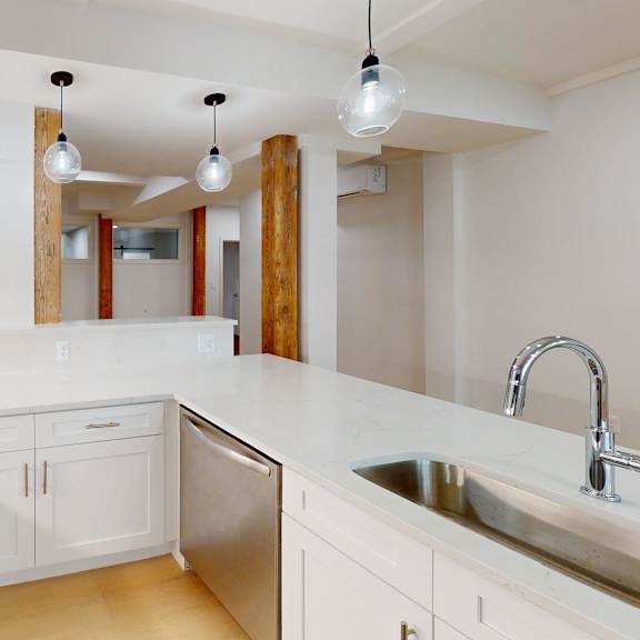a kitchen with white cabinets and a stainless steel sink.