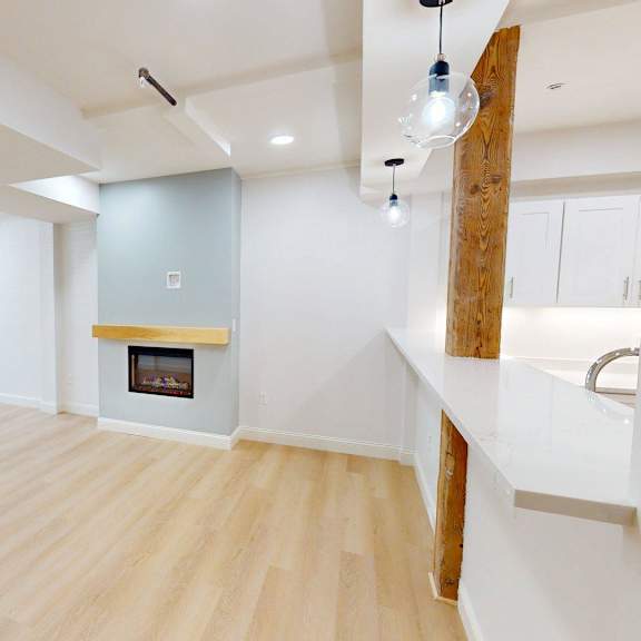 a spacious living room with a fireplace and wooden floors.