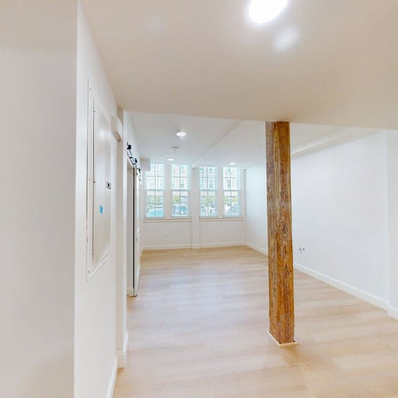 a long hallway with a wooden pillar in the middle.