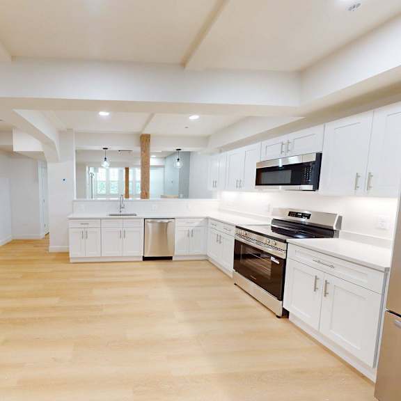 a kitchen with white cabinets and stainless steel appliances.