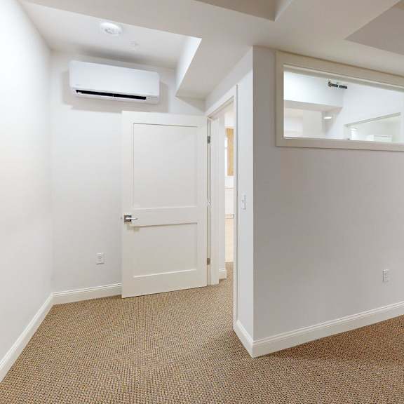 a room with a carpeted floor and a door leading to another room.
