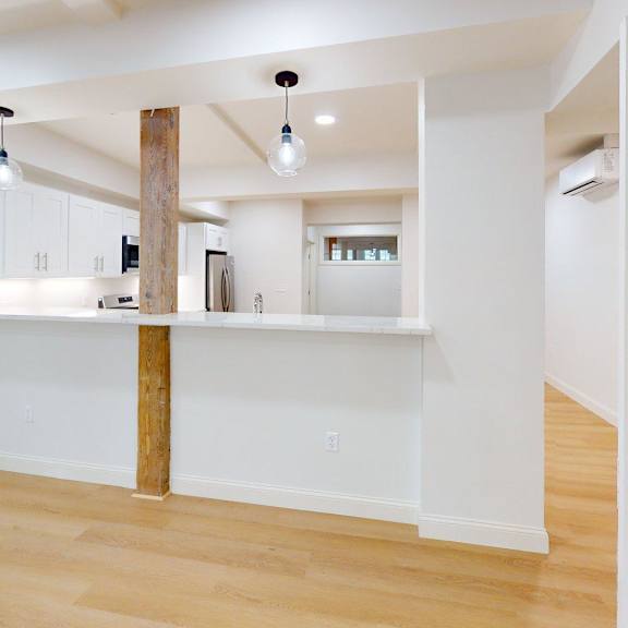 a kitchen with white cabinets and a wooden beam.