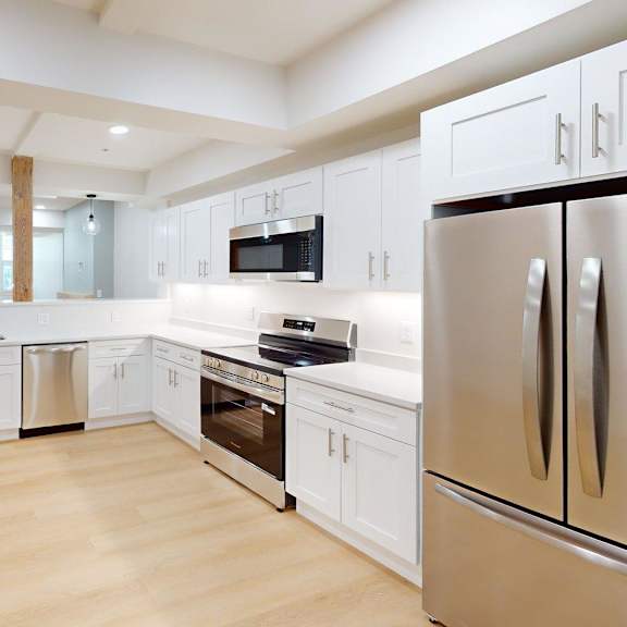 a modern kitchen with white cabinets and stainless steel appliances.