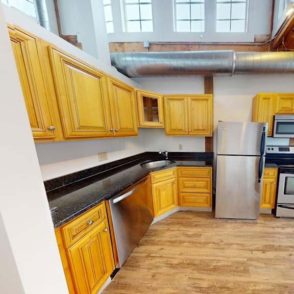 a kitchen with wooden cabinets and a black countertop.