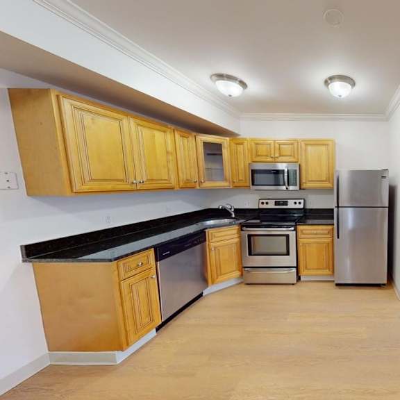 a kitchen with wooden cabinets and a black countertop.