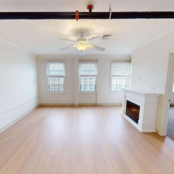 a room with a fireplace and a ceiling fan.