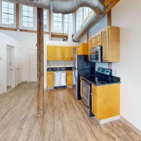a kitchen with wooden cabinets and a black countertop.