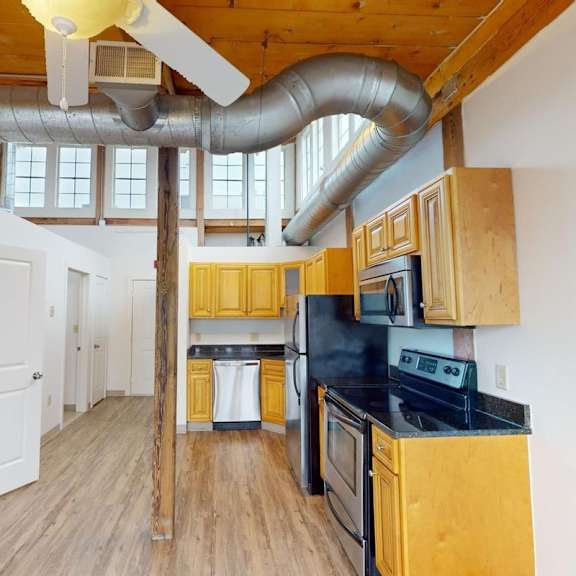 a kitchen with wooden cabinets and a black stove top oven.