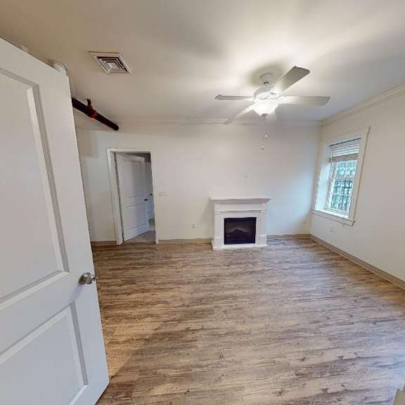 a room with a fireplace and a ceiling fan.