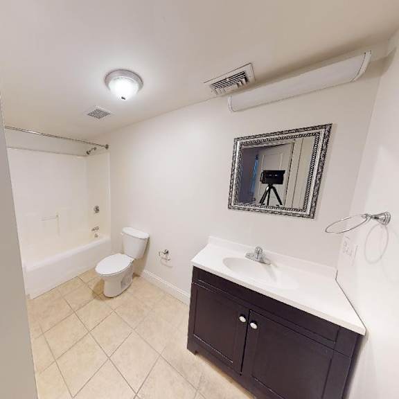 a bathroom with a toilet, sink, and mirror.