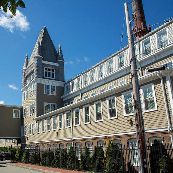 a building with a tower and a fence in front of it.