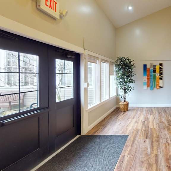 a hallway with a black door and a grey carpet.