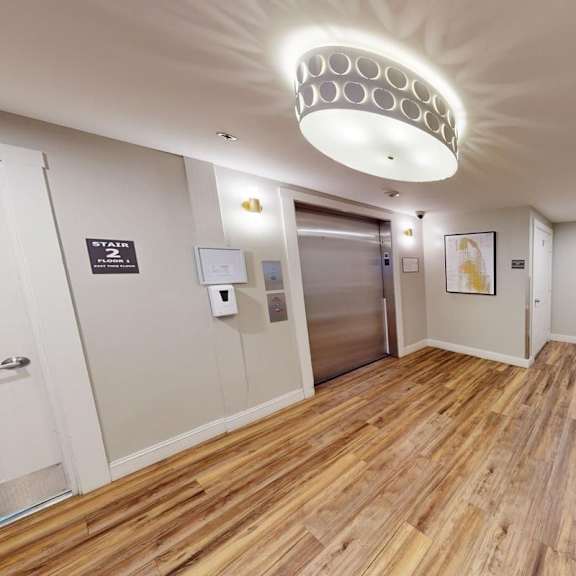 a hallway with a wooden floor and a bench.